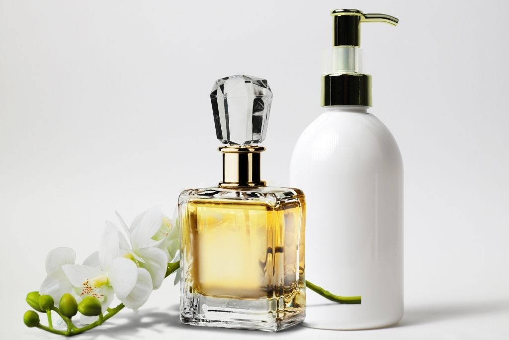 Lotion and perfume bottles with a stem filled with orchid flowers